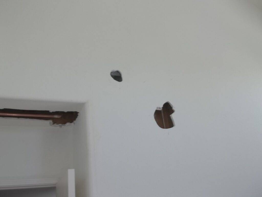 Chunky holes in drywall, about fist size, but too irregular in shape yet clean around the edges to be a fist