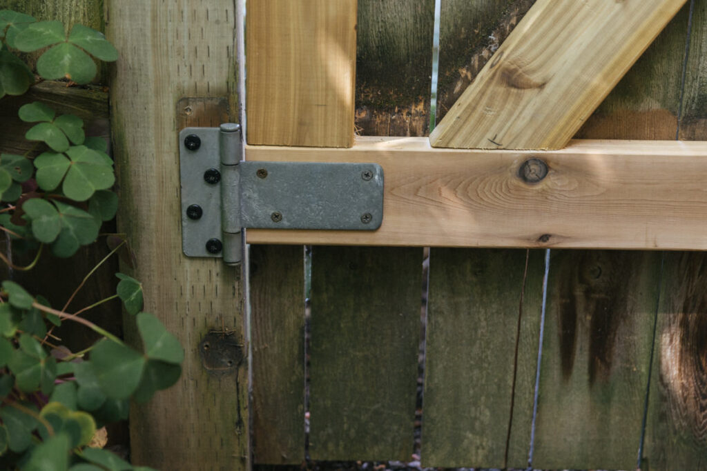 Fence gate with replaced wood and hinge