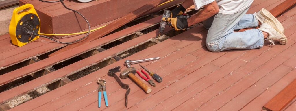 I mage of a man working on a deck. Repairing deck.